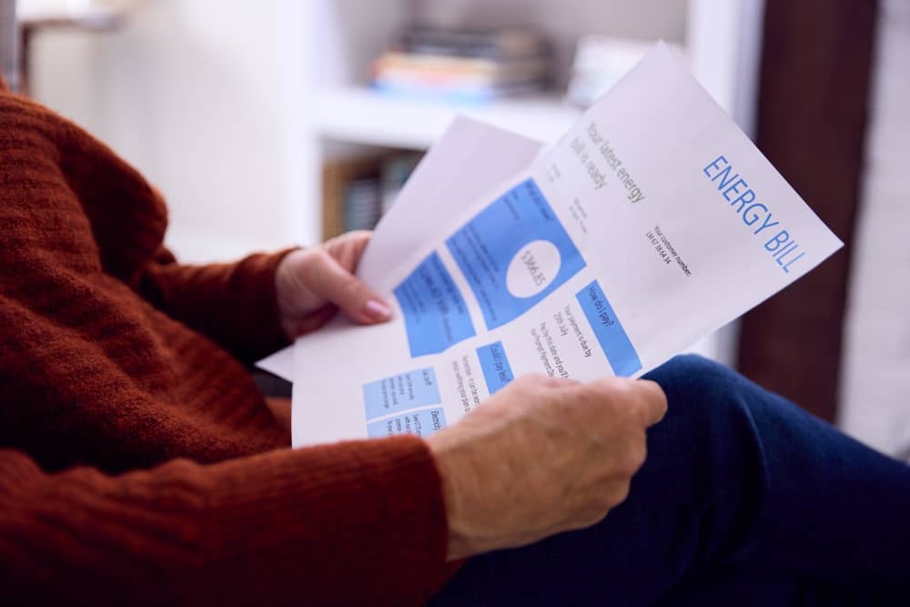 Close Up Of Senior Woman At Home Looking At USA Energy Bill During Cost Of Living Energy Crisis