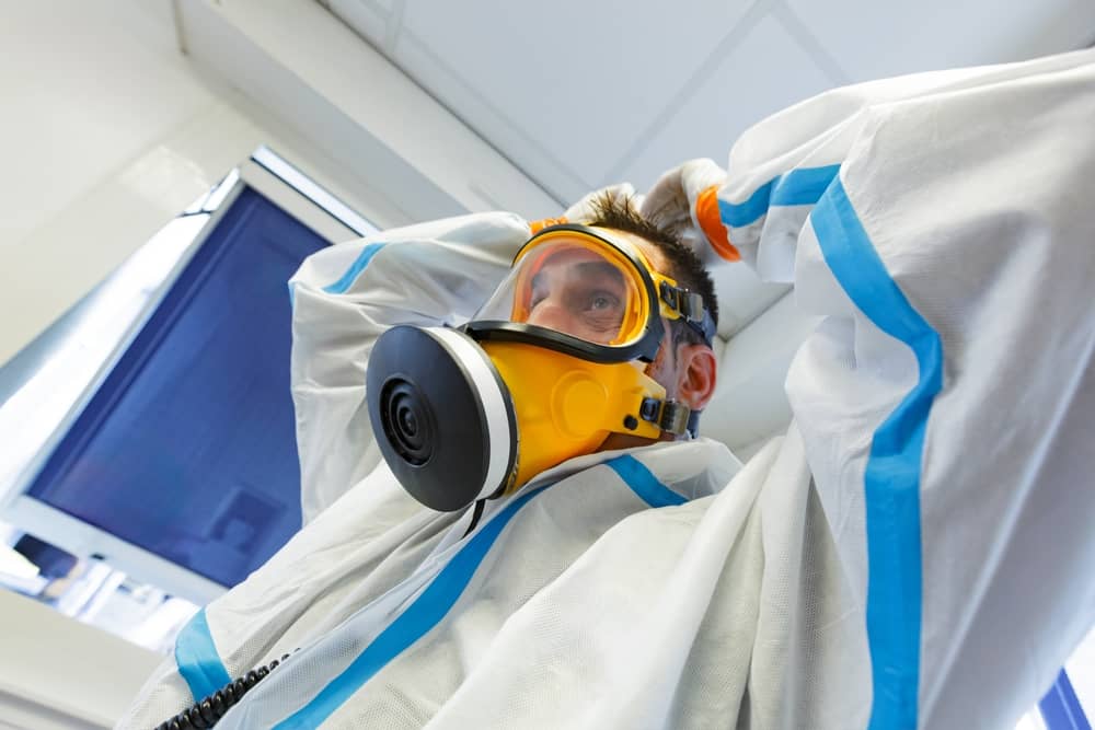 NORMANDY, FRANCE, OCTOBER 6, 2015: asbestos surveyor with ventilated mask and protective Hazmat suit, asbestos risk prevention training