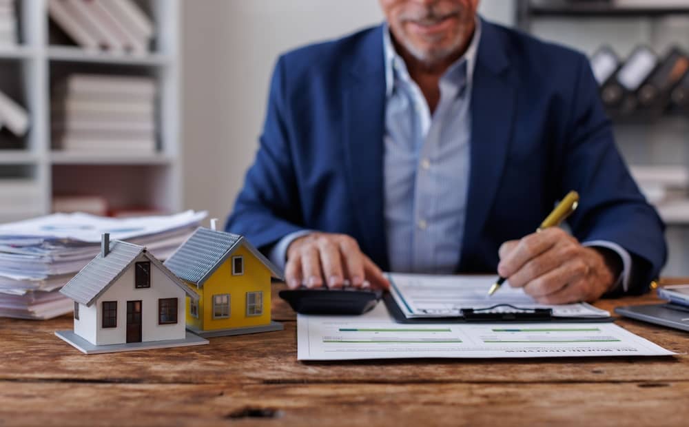 Real estate broker agent presenting and consult to customer to decision making sign insurance form agreement, buy and sell home model, concerning mortgage loan offer for and house insurance