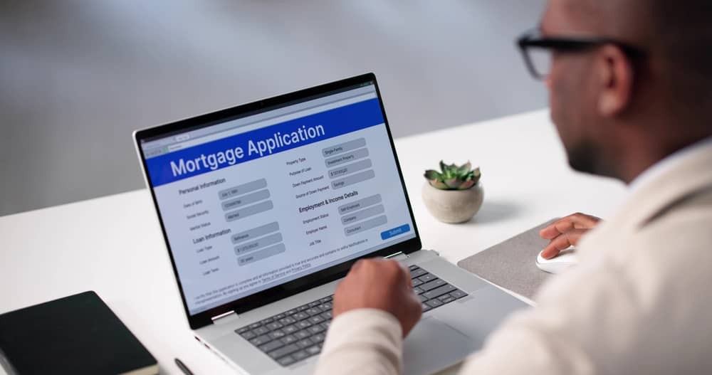 Real Estate Broker Filling Mortgage Application On Laptop Computer Online