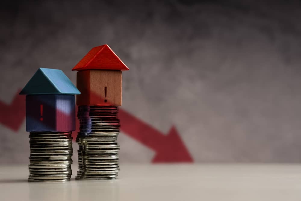 A downward red arrow with coins stacked House, depicting global recession, economic downturn, and significant Housing Market loss.