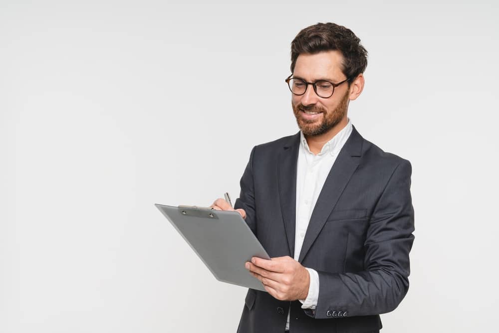 Caucasian businessman clerk corporate lawyer banker looking on clipboard isolated over white background. Manager checking preparing projects startups, finance deal, insurance contract, copy space